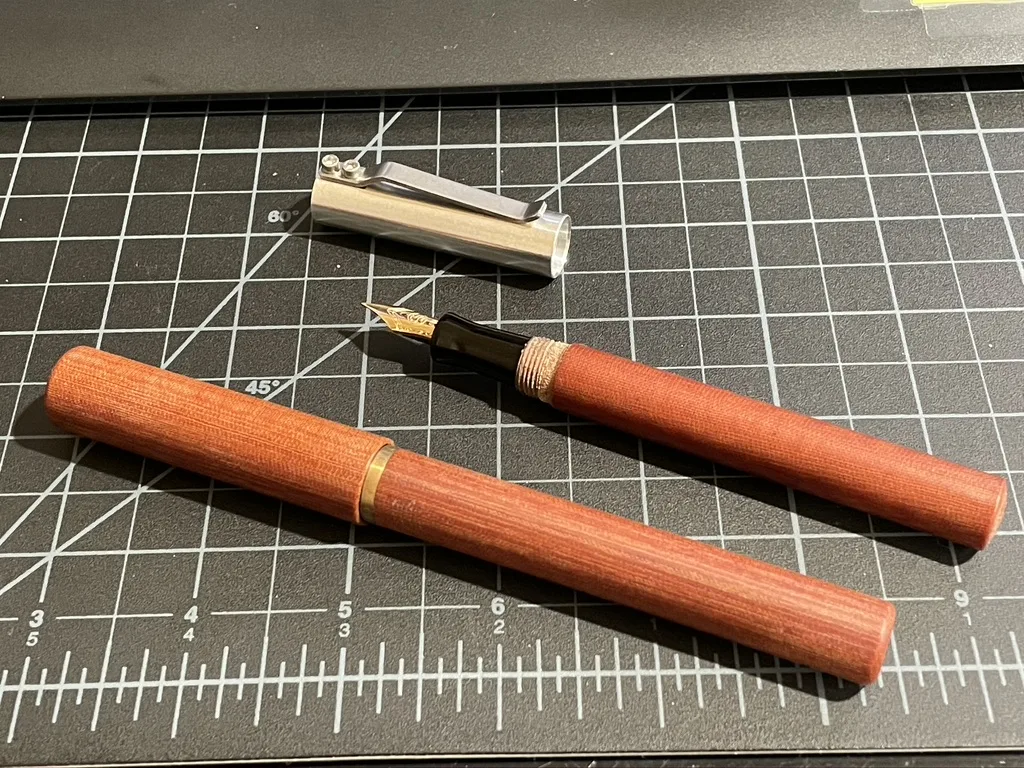 Wood body fountain pen with gold nib on cutting mat